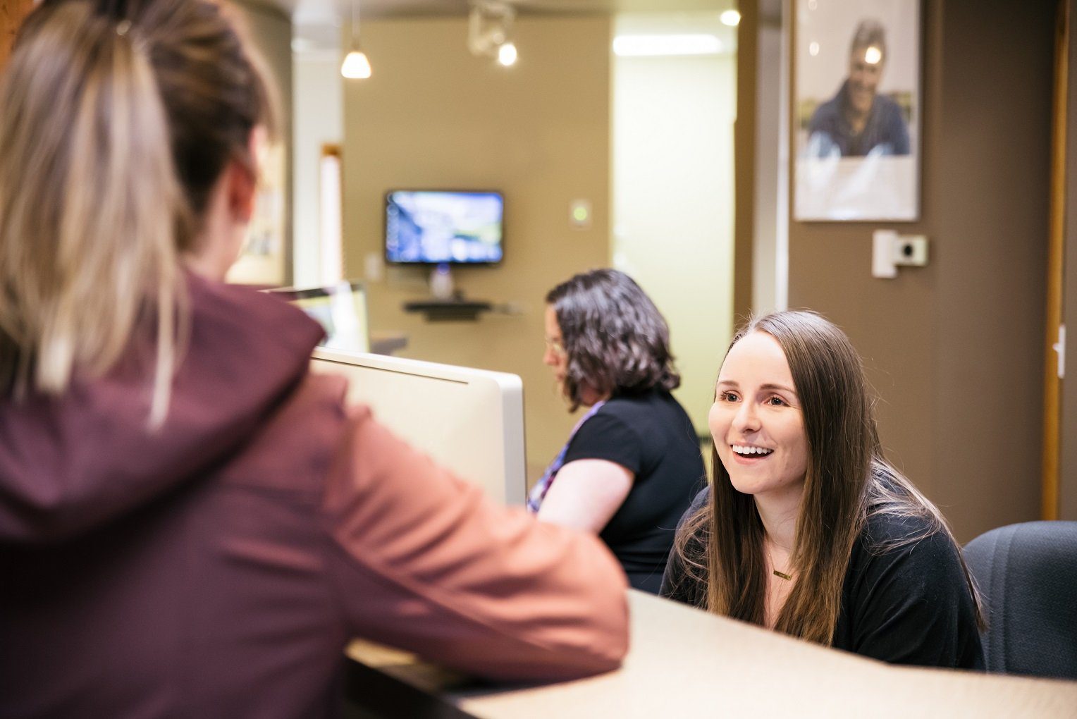 using your dental benefits by year end receptionist greeting patient