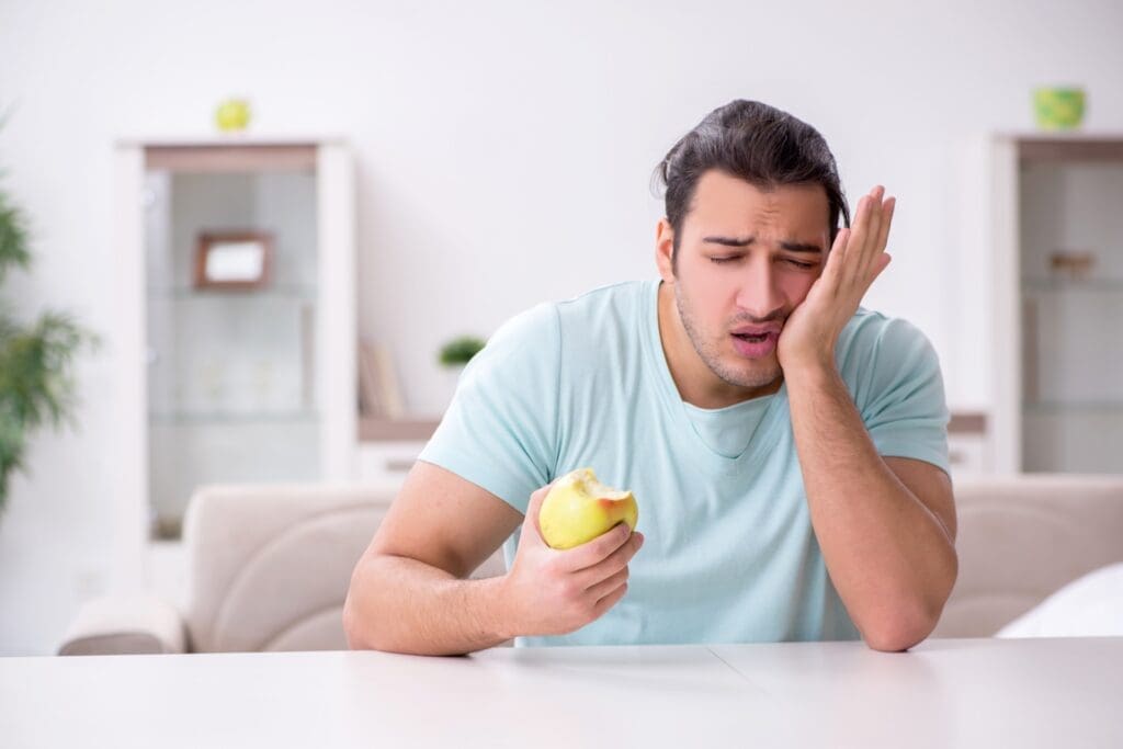 Young man experiencing pain when chewing