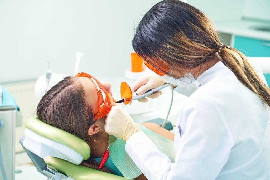 Girl at dentist having cavity filled