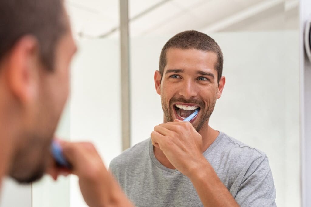 Man brushing his teeth to prevent gum disease