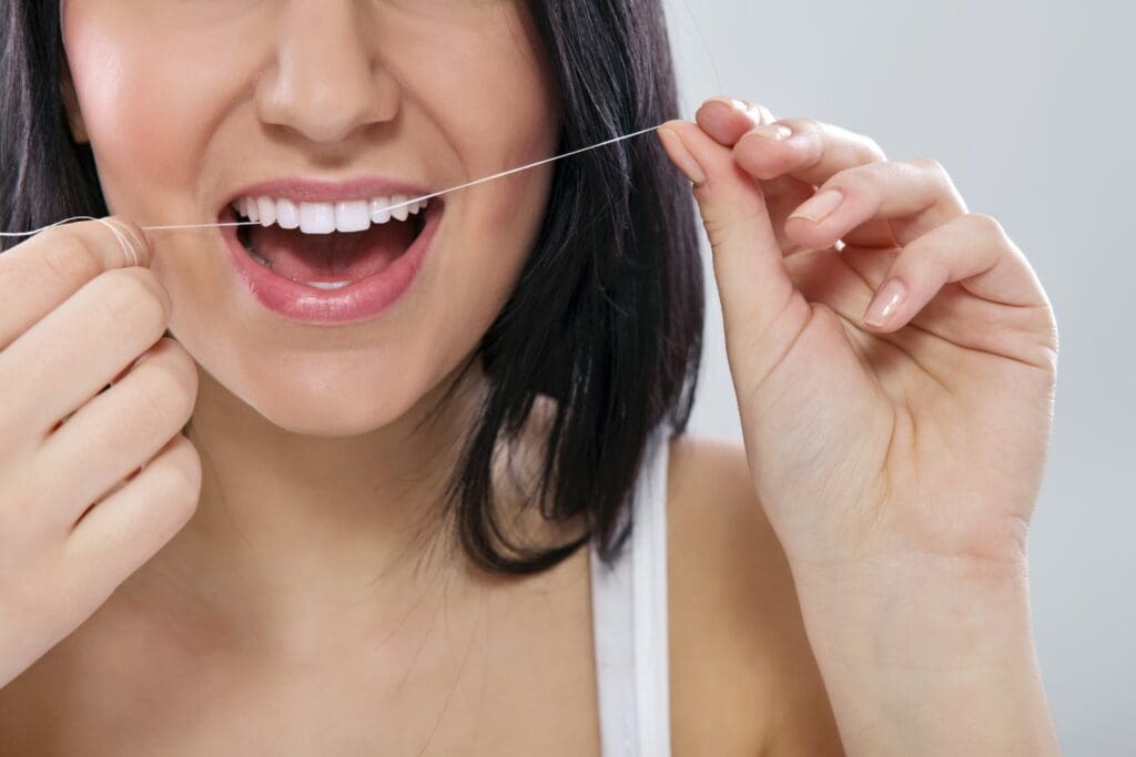 Woman flossing her teeth