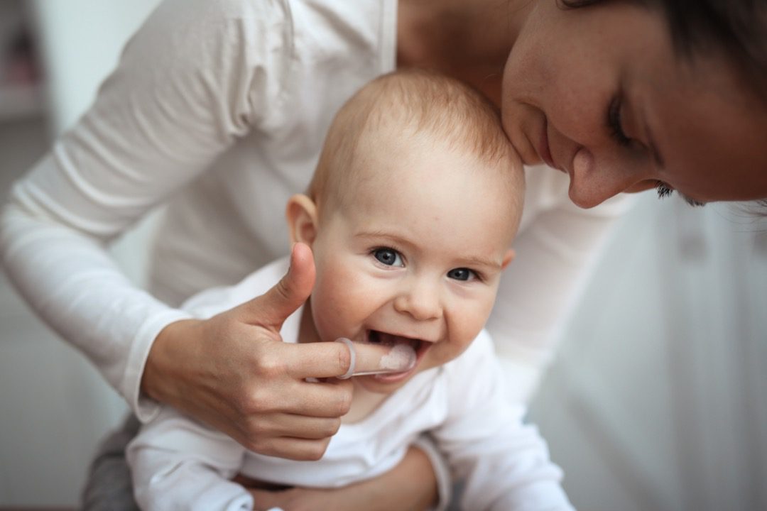 Parent cleaning baby's teeth