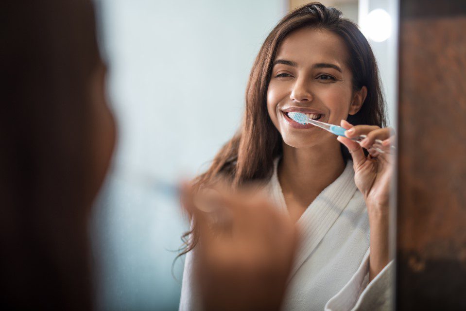 Young woman brushing teeth to prevent cavities